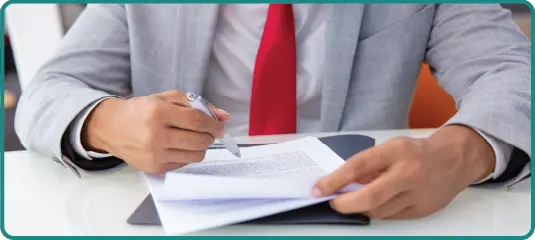 Picture of a man writing on a paper holding a pen in hand - Business License in Saudi Arabia